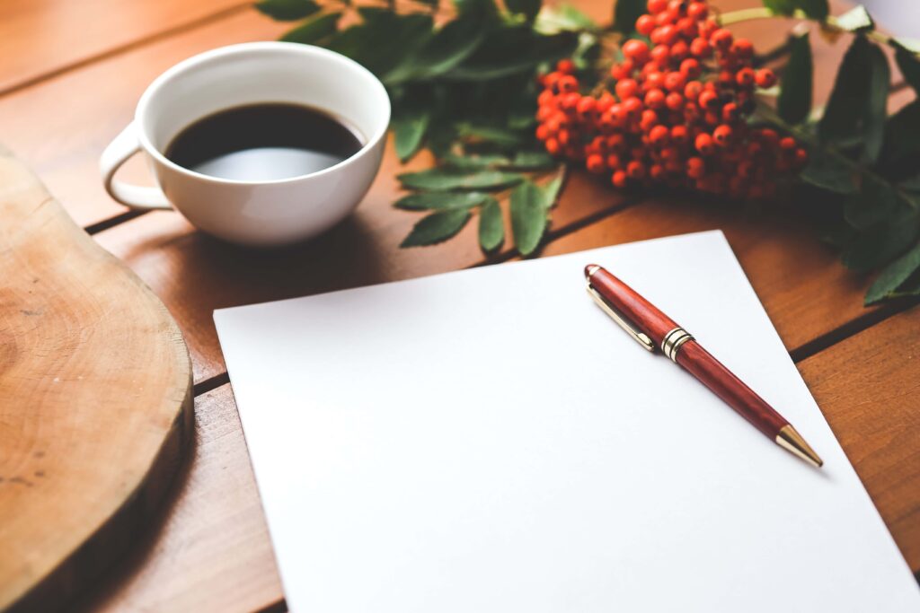 piece of blank paper with pen and cup of coffee