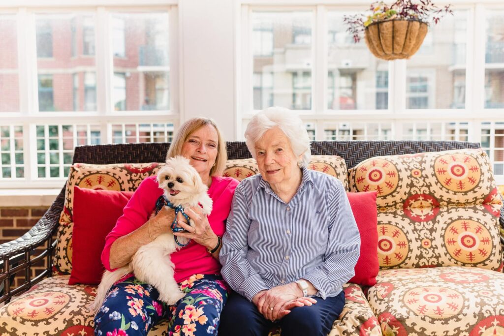 resident and family member sitting with small dog