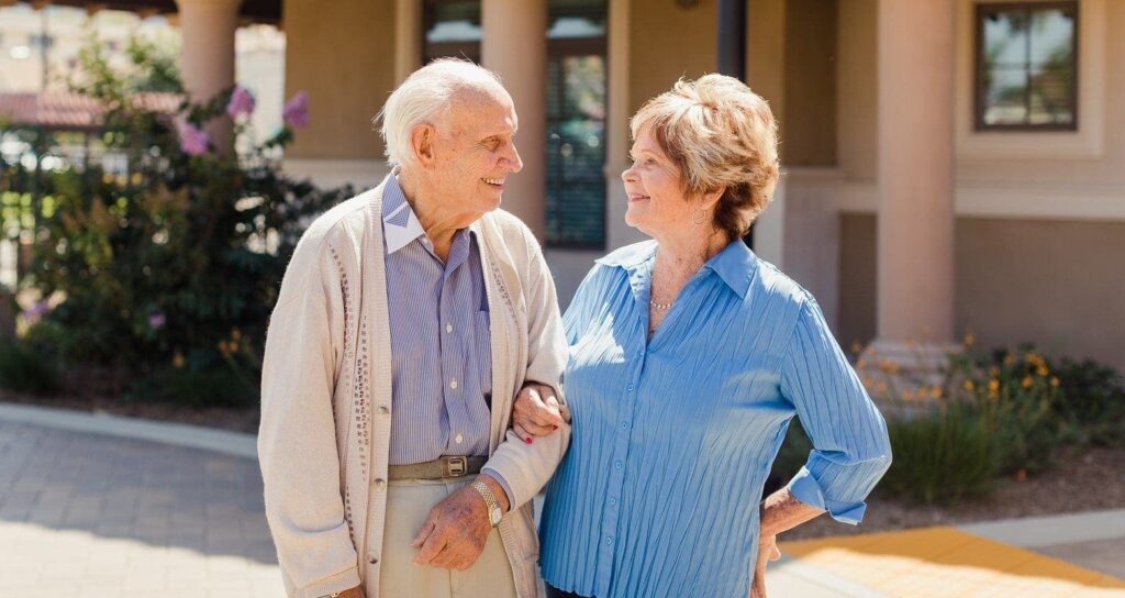 resident couple smiling at each other arm in arm