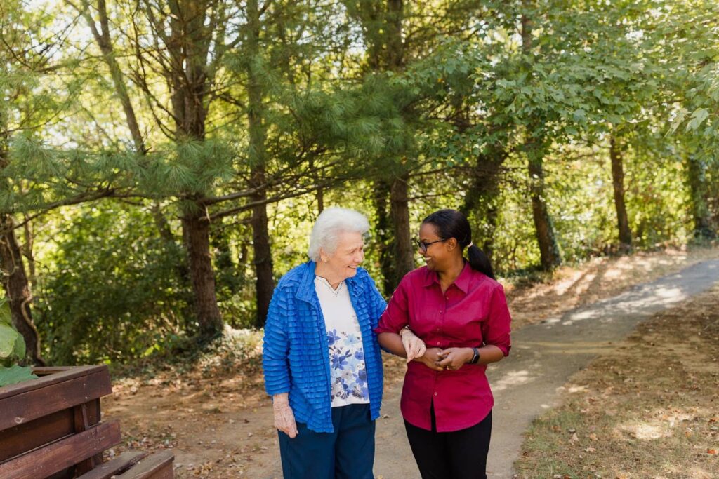 resident walking with care team member