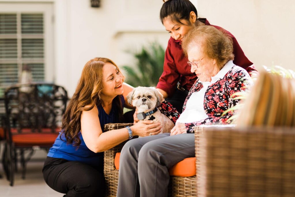 resident with care team members and small dog