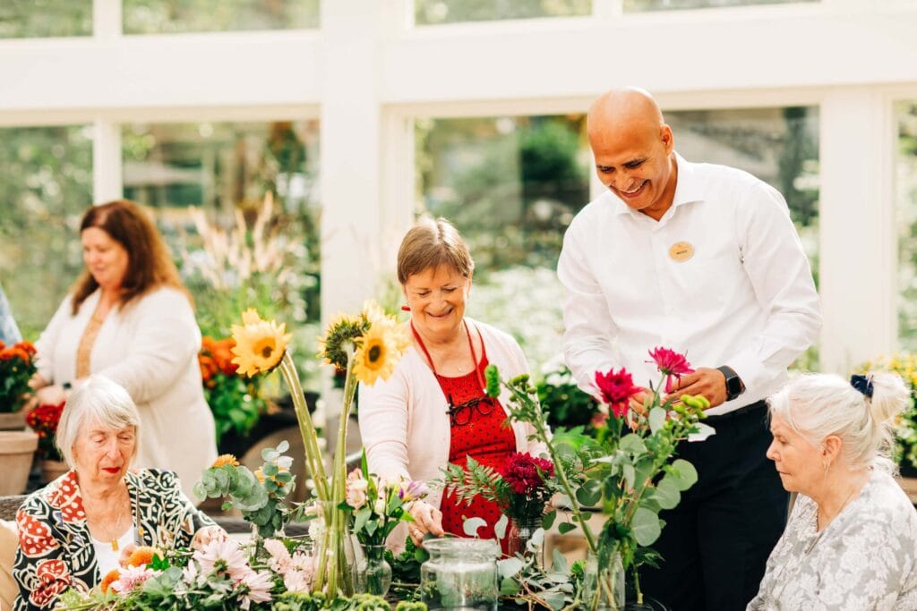 people smiling and planting flowers outdoors