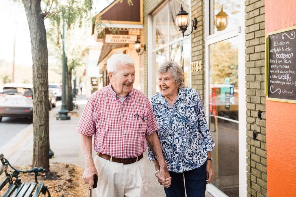 elderly couple walking through downtown street