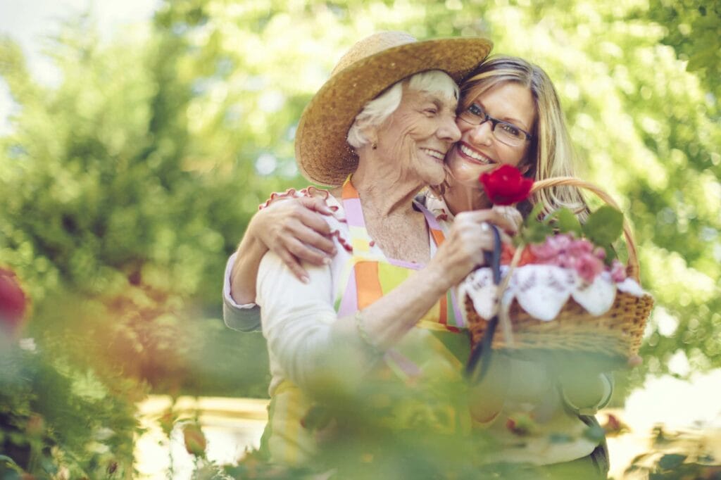senior mother and adult daughter gardening in summertime