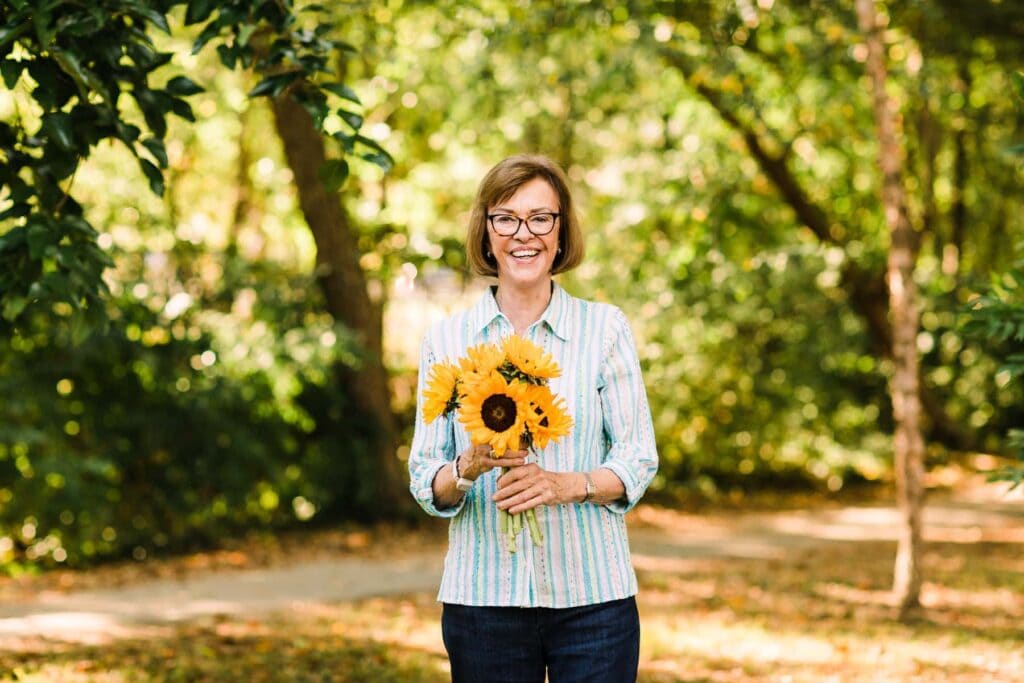 elderly woman holding sunflowers