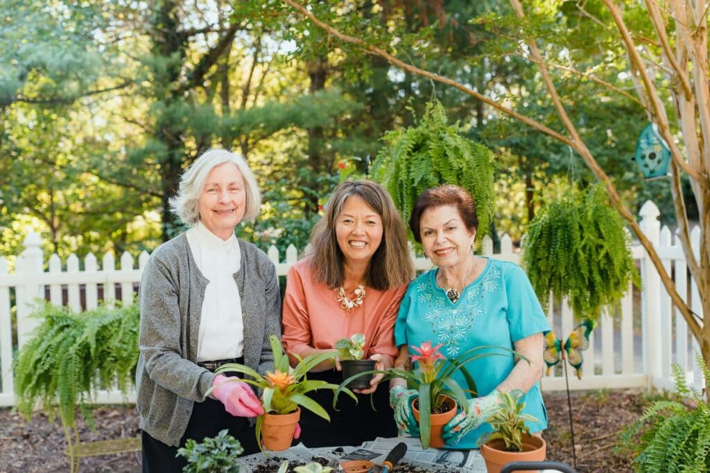 two residents and care team member gardening together
