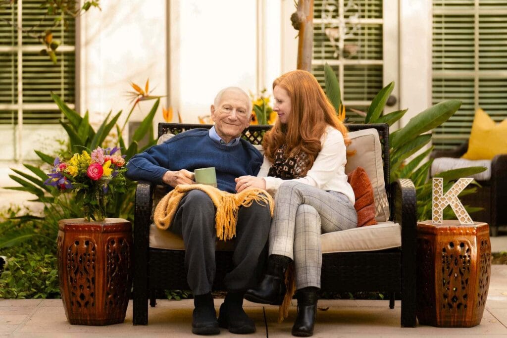 care team member and resident sitting on bench together