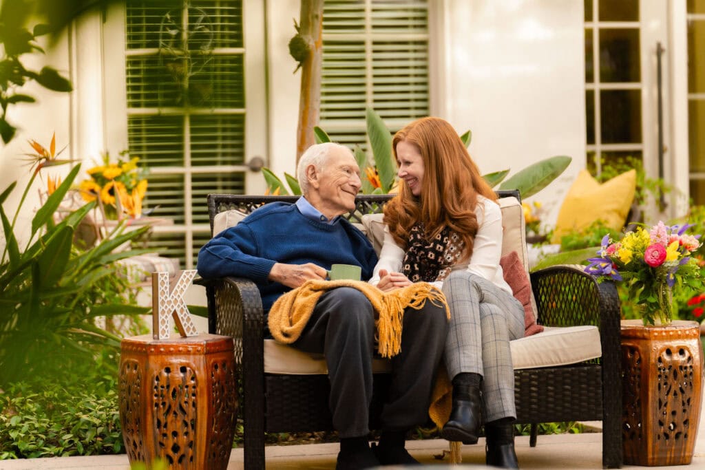 elderly man and woman sitting on bench together