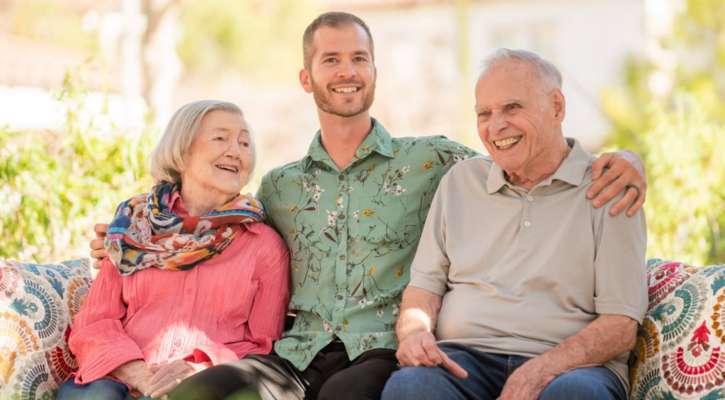 A man and two women sitting on a couch with an older man
