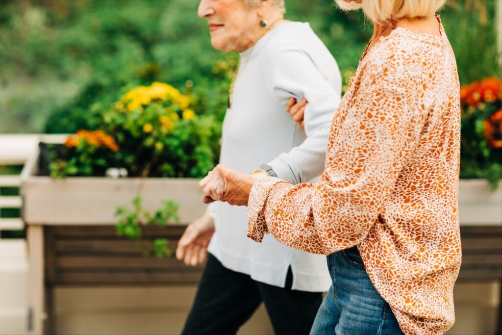 woman and eldely woman walking hand in hand