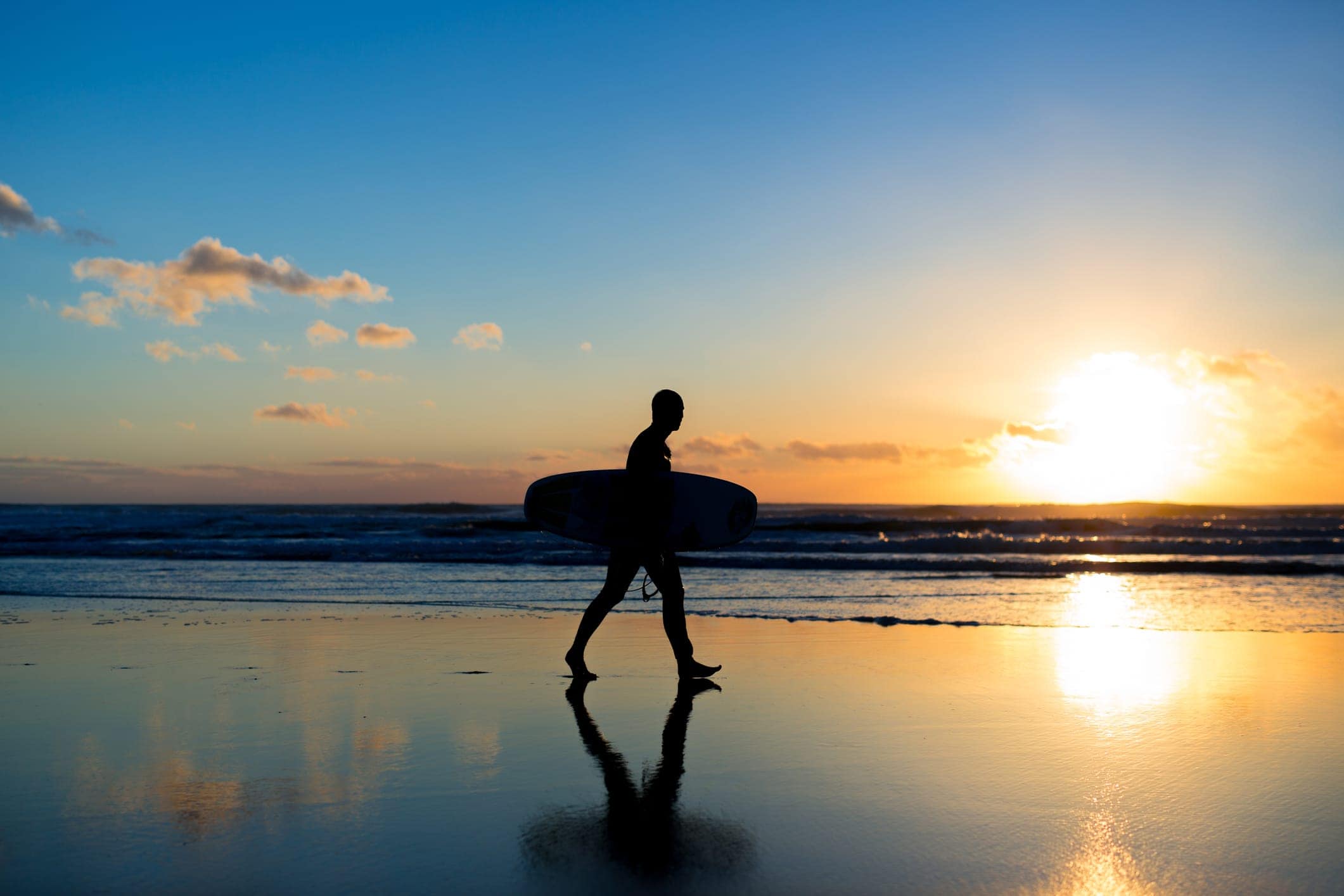surfer walking along beach
