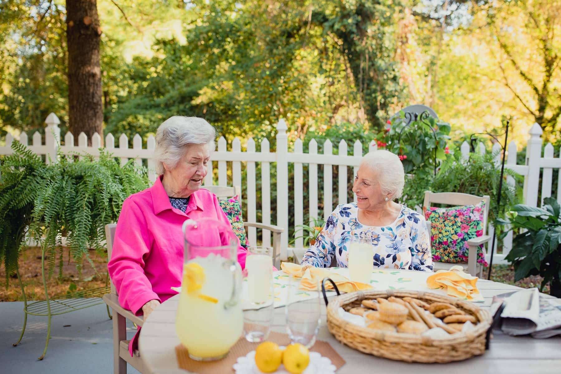 elderly women enjoying lemonade and snacks on patio