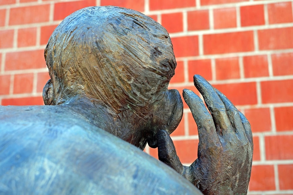 bronze sculpture of man listening
