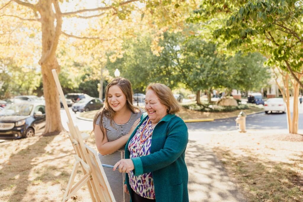 resident painting with caregiver
