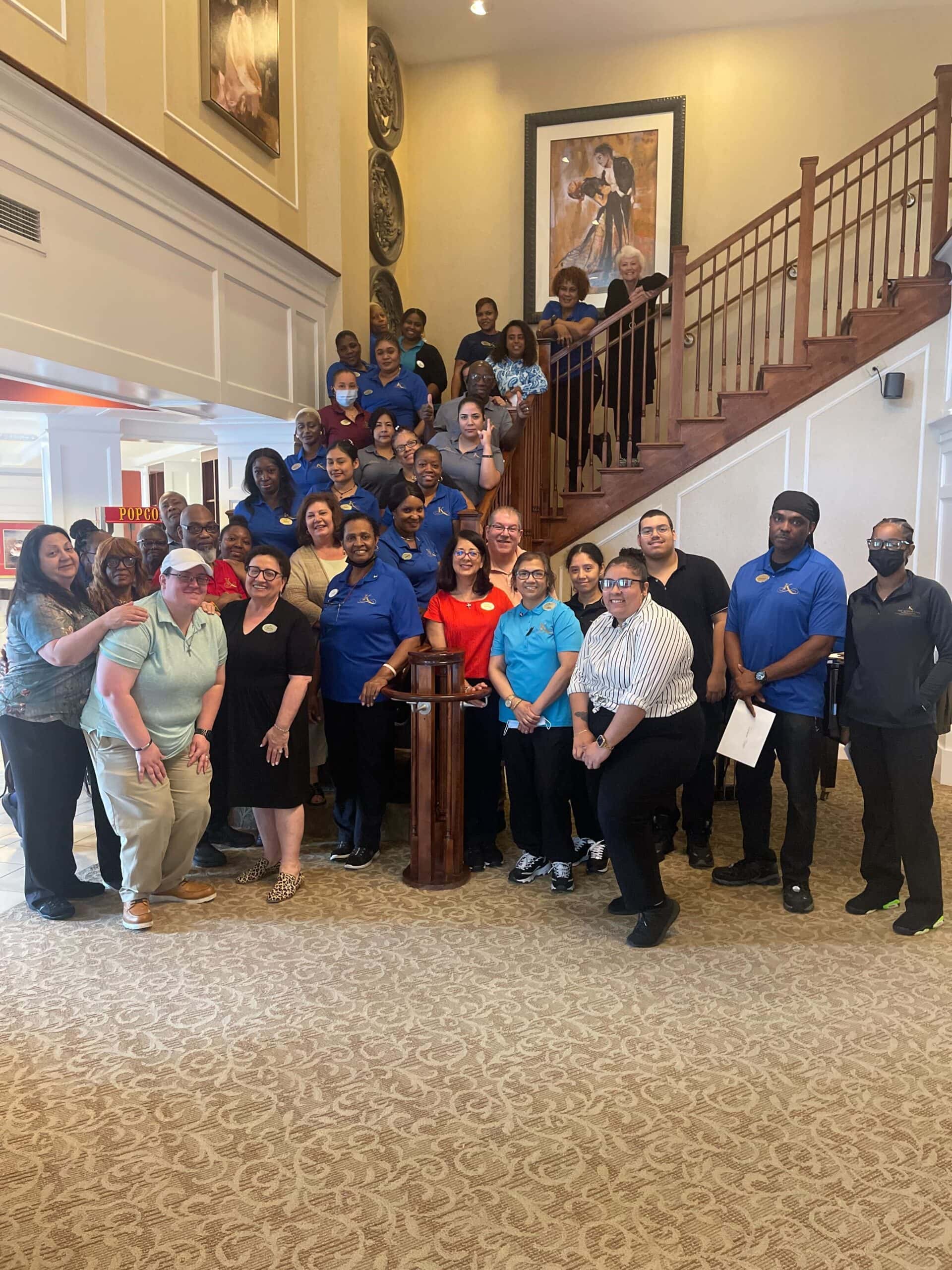 Kensington staff posing up staircase