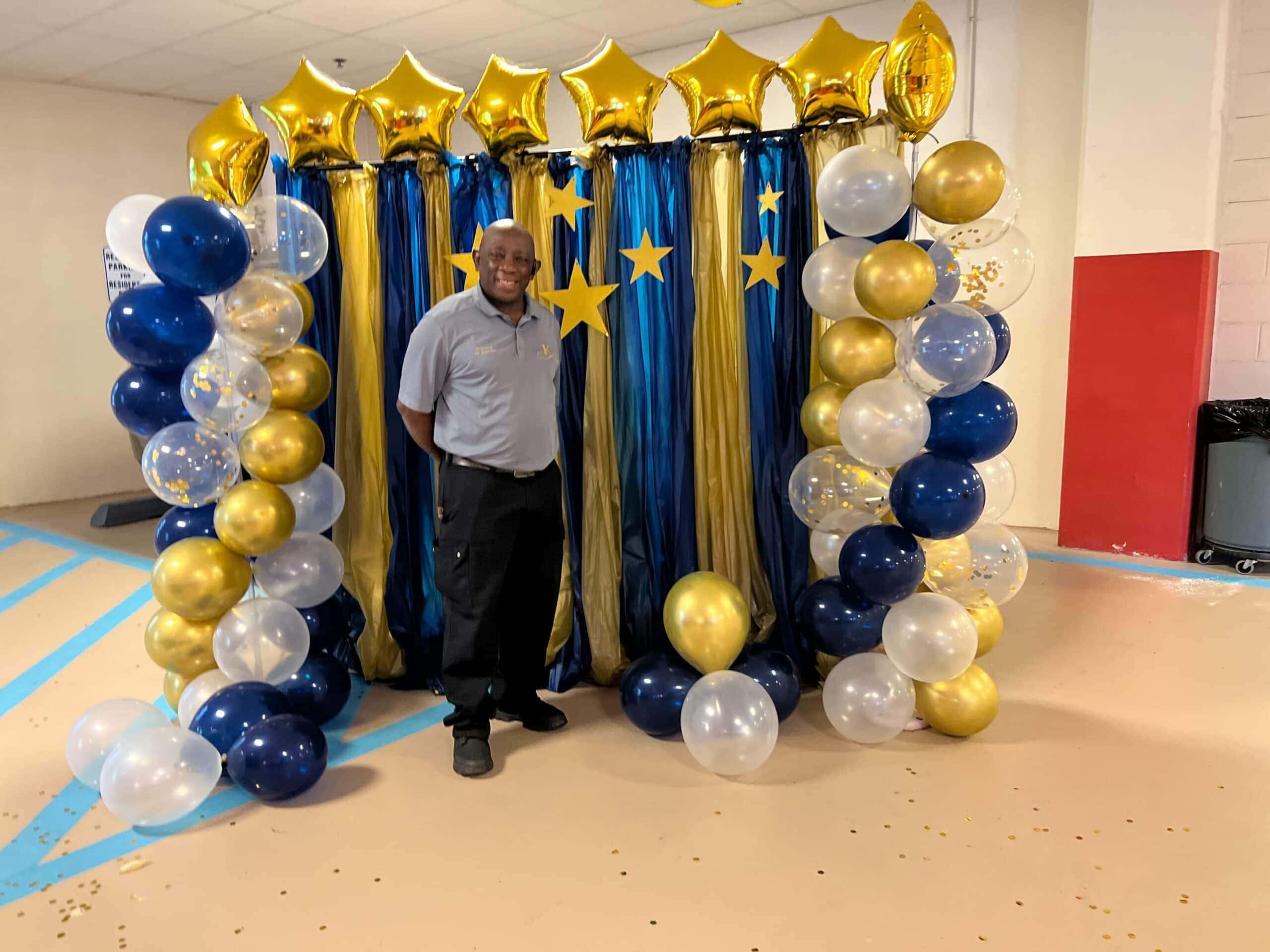 team member at community event posing with photo backdrop