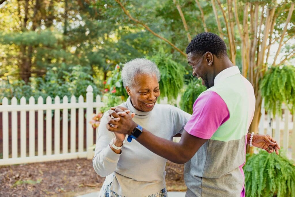 family member and resident dancing