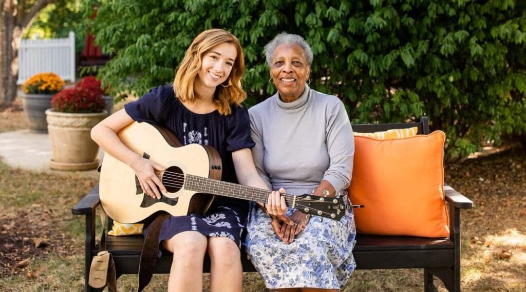 music therapist with guitar and elderly woman