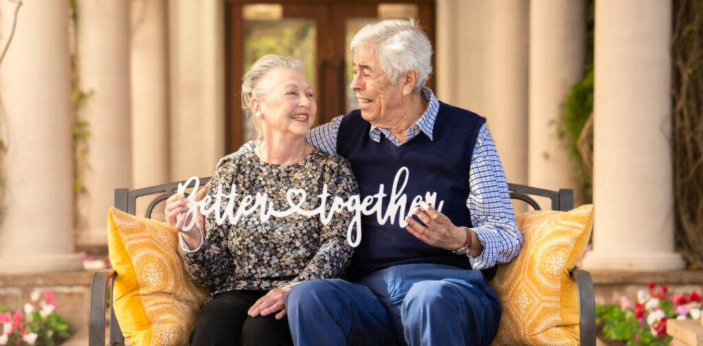 Senior couple with a sign that reads better together